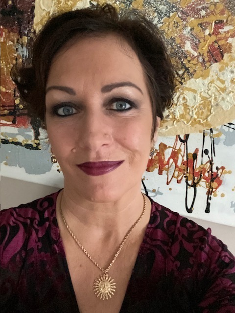 A selfie of Catherine Carr in front of one of her paintings